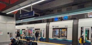Some passengers catch a northbound train at U District Station while other wait on seats for the southbound.