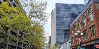 Op-Ed: It’s Time to Bring Transit Back to Seattle’s First Avenue A view north up First Avenue shows a hodge of Pioneer Square historic brick buidlings, tall glass scrapers and a large parking garage.