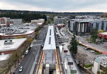 A Local’s Guide to the Downtown Redmond Light Rail Extension A elevated platform sits on the side of an urban road with a smattering of large midrise apartment buildings bordering it.