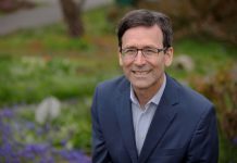 Ferguson’s Continued Focus on Austerity Places King County in Jeopardy Ferguson is a middle aged White man in glasses in a suit posing by some flowers