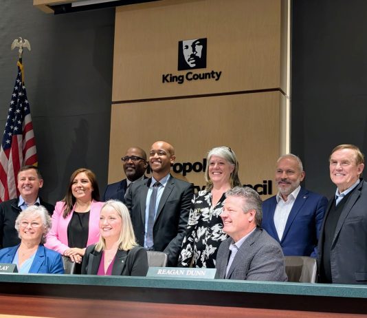 King County Restructures School Impact Fees to Comply with State Law Shannon Braddock takes a seat in the middle of the dais with the nine County Councilmembers around her during her swearing in ceremony.