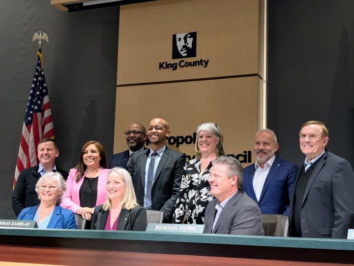 King County Council with Shannon Braddock _ Trumm 20250401 Shannon Braddock takes a seat in the middle of the dais with the nine County Councilmembers around her during her swearing in ceremony.