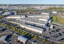 Op-Ed: It’s Time to Uproot ICE Penal Colonies Like Tacoma’s GEO The two-story detention center has white walls and is surrounded by asphalt parking.