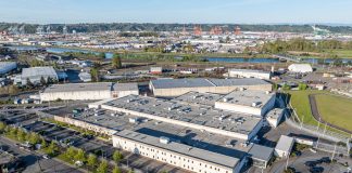 The two-story detention center has white walls and is surrounded by asphalt parking.