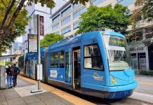 Fare Hike Proposal Would Increase Seattle Streetcar Rides to $3 A blue streetcar at a stop along Westlake Avenue with three passengers on the platform.