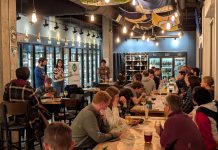 Campaign Volunteer Training Sessions Headline The Urbanist’s August Events Attendees fill seats in long tables at Teku Tavern two members of House Our Neighbors present to the group.