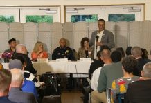 High Point Safety Town Hall Is a Low Point for Saka Police Chief Shon Barnes sits at the center of the panel and Saka stand in front the table with the mic.