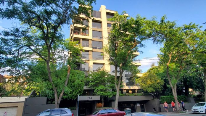 714 Belluve Ave-Single Stairv3 by Markus Johnson The skinny modern eight-story towers peeks out between two trees.
