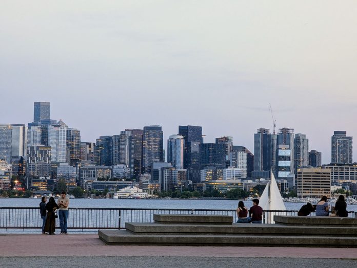 Gas Works Park with sail boat - Trumm 20250606 A sailboat passes in front of the seating area at Gas Works with the skyline in the distance