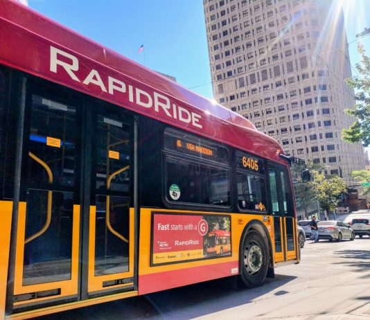 King County Advances K Line Designs for Eastside’s Next RapidRide A bright red RapidRide bus with the sun glinting in the sky