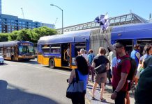 Bus Advocates Race Route 8 to Bolster Case for Improvements A group of pedestrians that raced the Route 8 with two buses in the background.