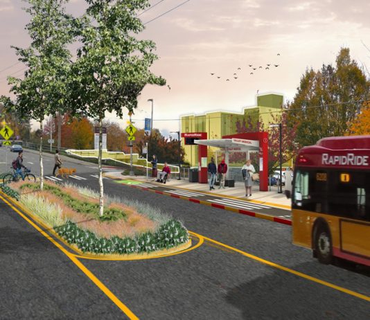 King County Council Unsnags RapidRide I Line After Property Disputes A rendering of a RapidRide bus arriving at a newly rebuilt bus stop with bus shelter and RapidRide pylon, with a median in the street adding trees and pedestrian safety. Riders wait under the shelter and two people use the cross walk, one walking a bike.