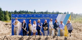 Sound Transit Breaks Ground on Stride Electric Bus Base in Bothell Action shot catches the ceremonial first shovelful of dirt from a row of officials in mid-air.