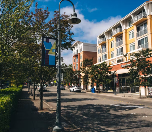 Mercer Island’s Growth Plan Ruled Out of Compliance with State Law A tree lined street in Mercer Island's town center, with a four story building on the other side of the street