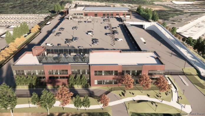 An aerial image showing two story brick office building with a large parking structure behind it to house battery buses and employee parking.