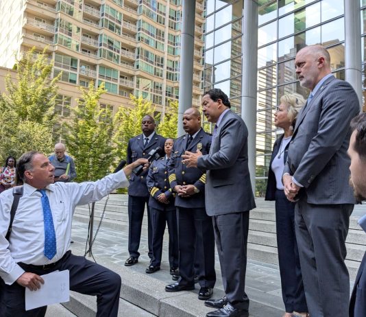 Harrell Pledges Police Contract by Year End – Adding Election Wrinkle Officials including Bob Kettle and Debora Juarez and SPD top brass stand on the steps of Seattle's US Courthouse with a reporter outstretching an arm holding a mic to interview them
