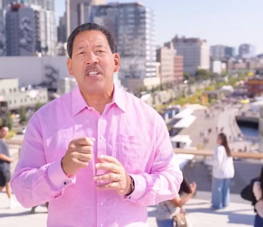 Harrell Budget Doubles Down on Police Spending Harrell weather a pink button up shirt with pedestrians on the Overlook Walk in the background.