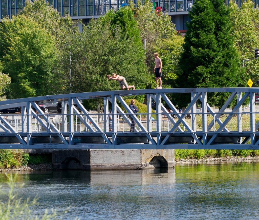 two guys jumping off the top of the ped bridge