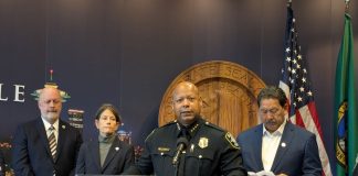 Barnes standard at the lectern with the City seal behind.