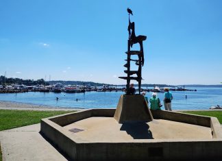 Kirkland Voters Maintain the City’s Course, Rejecting Anti-Growth Push A tower-like metal sculpture crowns Kirkland's Marina Park, with a few pedestrians walking on the path along its edge. The marina and Moss Bay is in the distance.
