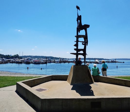 Kirkland Voters Maintain the City’s Course, Rejecting Anti-Growth Push A tower-like metal sculpture crowns Kirkland's Marina Park, with a few pedestrians walking on the path along its edge. The marina and Moss Bay is in the distance.