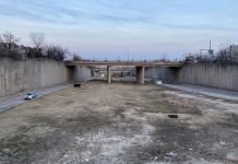 Book Review: How a Highway Map Wrecked Baltimore A barren trenched has an access road on the city but empty field down the middle with bridges spanning the trench to connect the street grid.