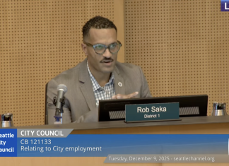 Seattle Approves Controversial Police Guild Contract, Three Councilmembers Dissent Councilmember Rob Saka sits on the council dais in a tan sportscoat.