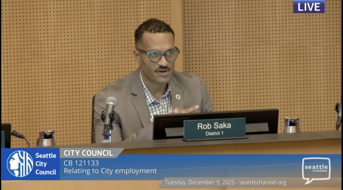 Three Councilmembers Dissent as City Approves Controversial Seattle Police Guild Contract Councilmember Rob Saka sits on the council dais in a tan sportscoat.