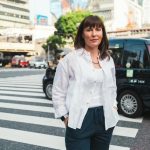 Kadie is a brown-haired woman standing in a city crosswalk.