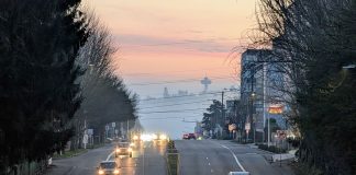 The view south toward the Space Needle from Fremont with a misty evening giving the sunset a peach tinge.