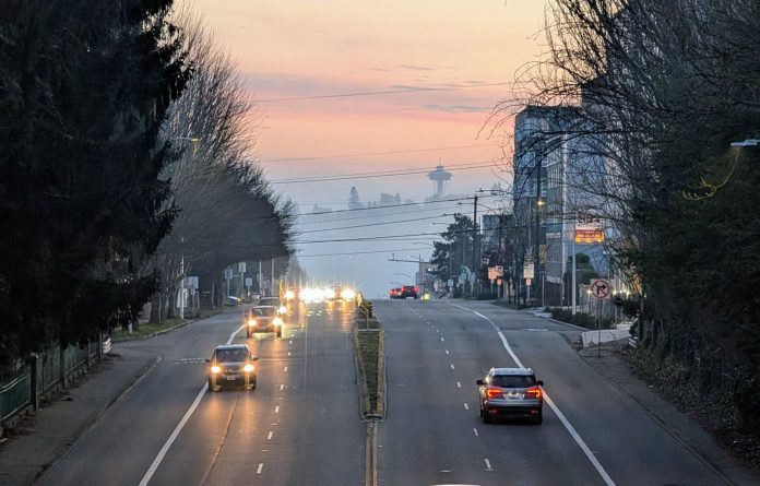 The view south toward the Space Needle from Fremont with a misty evening giving the sunset a peach tinge.