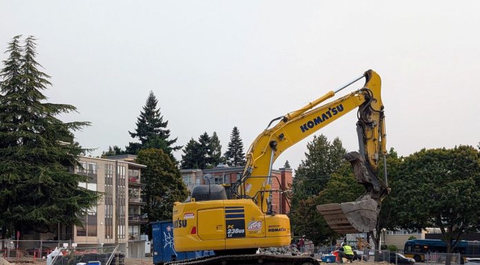 Seattle Poised to Remove SEPA Review Hurdle for Most Housing Projects A Komatsu backhoe at a large midrise construction site on Stone Way in Fremont.