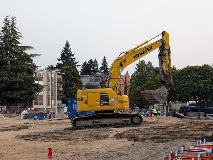 A Komatsu backhoe at a large midrise construction site on Stone Way in Fremont.