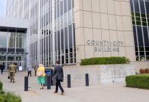 ICE’s Tacoma Detention Center Targeted in New Lawsuit Alleging Abuses A stream of people in formal clothes walk into a modern concrete and plate class courthouse building