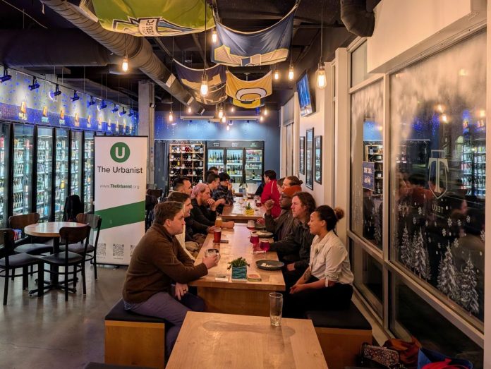 About 20 urbanists sit around a long table in the tavern.
